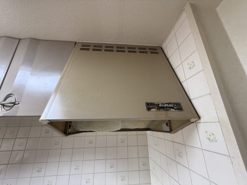 大きなブーツ型のレンジフードは、フィルターの掃除が難しく、油で黄ばんでいました。換気性能の低下も懸念されるため、最新のスリム型への交換をご提案させていただきました。
